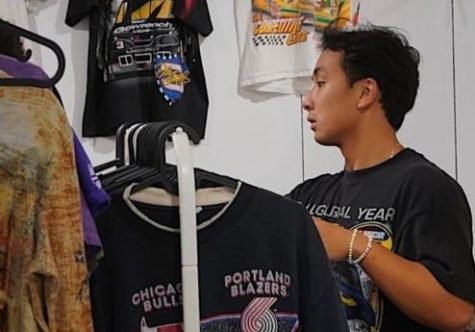 Alumnus Duy Bui arranges his clothing for sale at a pop-up shop he attended. He loves to connect with community members at these events. (Photo courtesy of Duy Bui)