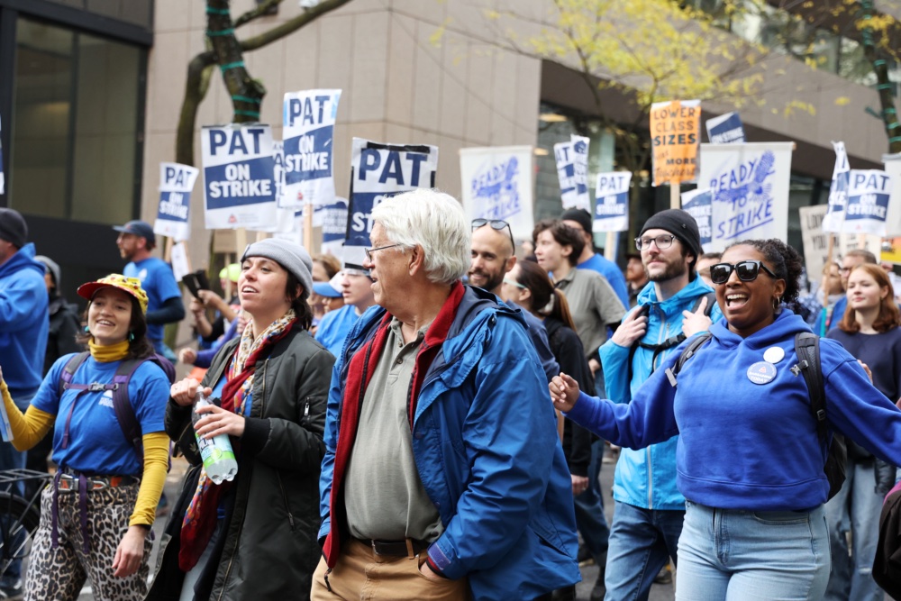 Portland teachers sing and swing their arms in rhythm to music as they chant. They all don large smiles that symbolize their joy and hope for a better PPS future. 