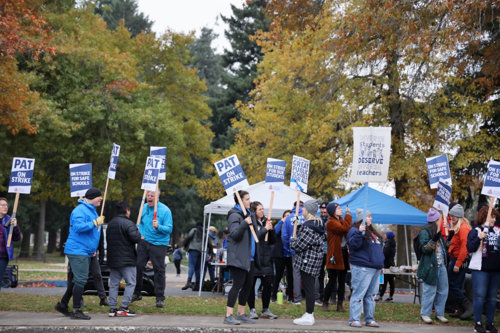 Teachers gather once again after having taken a break to get some food. Food stands can be seen right behind the strikers under the blue and white covers. 