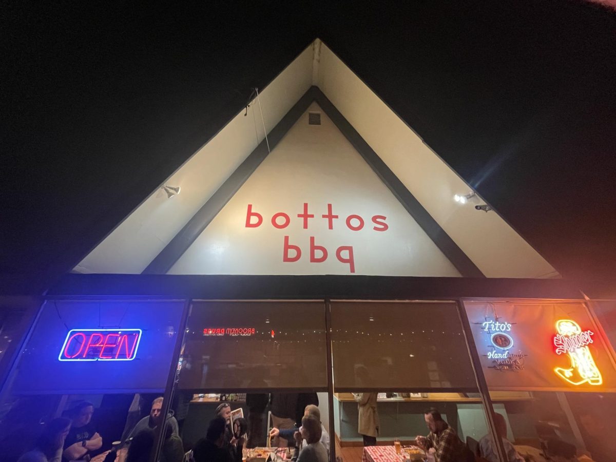 The glowing lights shine on the front of the restaurant. The bright red letters make the building pop.