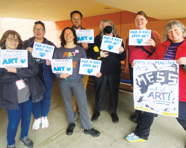 A group of PPS teachers are holding signs advocating for the art program. This is a way that the community is showing their support for students in Head Start.