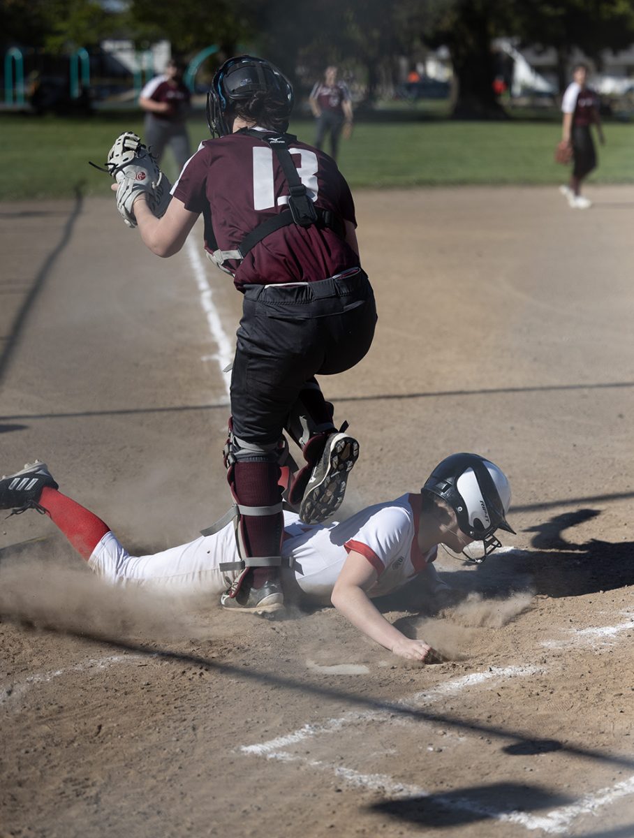 Junior Rebecca Culp dives into home base. She scores a run for the team.