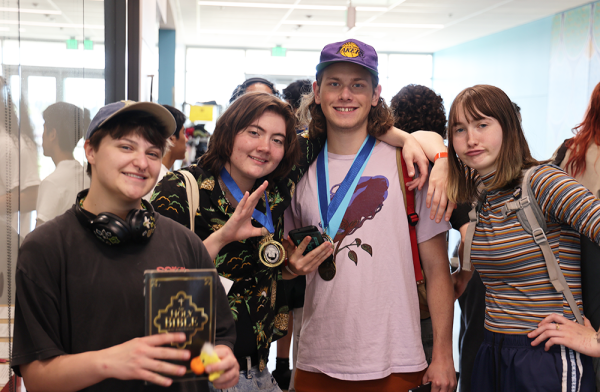  Finn Amos, Royce-Avan Brown, Quentin Stellpflug and Greta Boelling pose together near the office. Brown flashes the valediction medal around his neck while the friends smile in each other’s company.