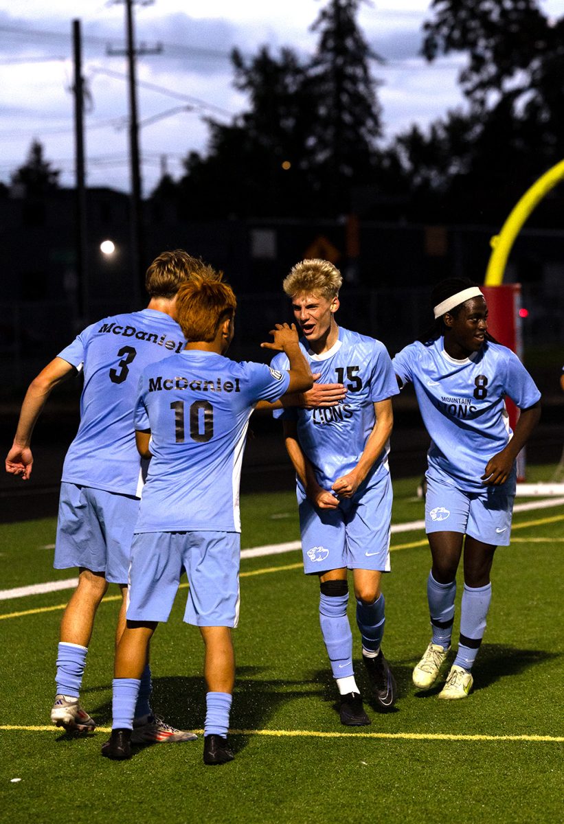 Sophomore Judah Ostrand celebrates his first high school goal. His team comes over to congratulate him.