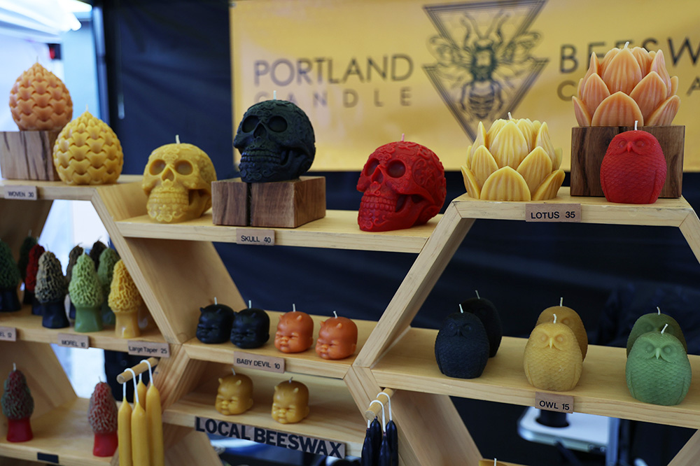 The Portland Beeswax Company sells candles in a diverse amount of colors, shapes and sizes. The most popular candles, Fratis mentioned, are the baby devil candles located at the center of the stand and the freestanding ridged tapers placed on the sides. Other candle shapes include sugar skulls, morel mushrooms, lotuses and owls. Access to the online shop for this company can be obtained by going to the portlandbeeswaxcandlecompany.com website. 