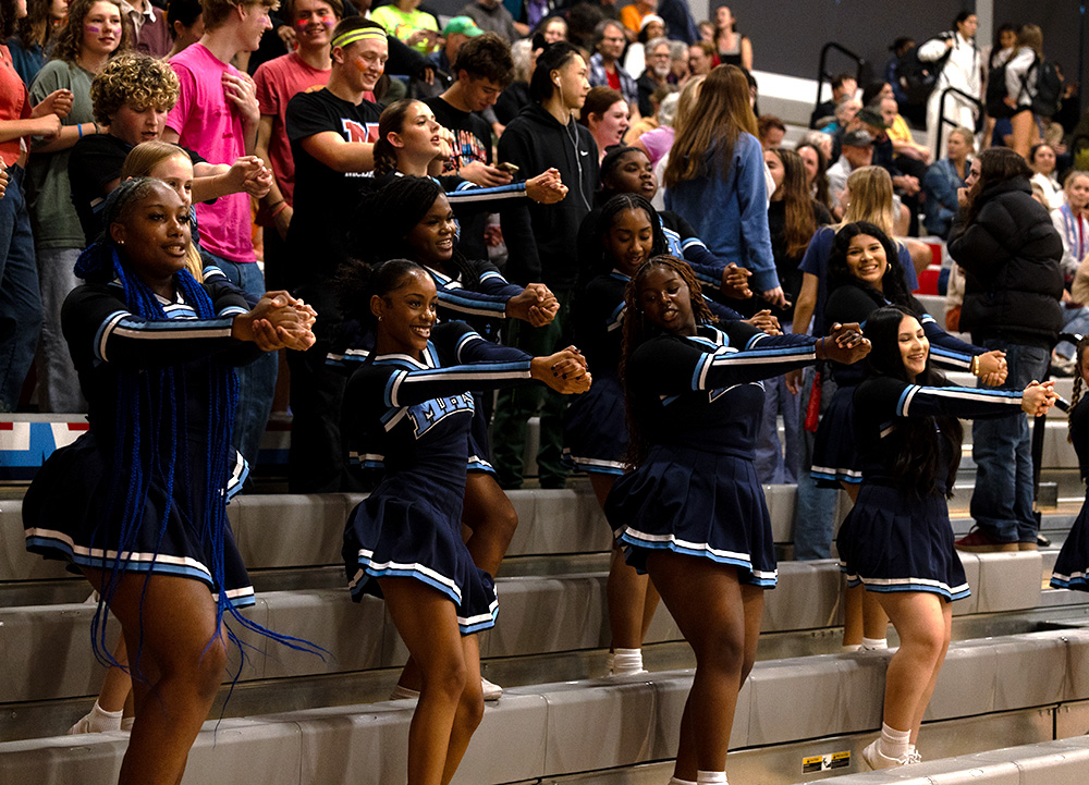 Cheer team performs on bleachers as McDaniel volleyball competes against Wells. They are looking forward to competing  in the homecoming game, which is a few days later. 