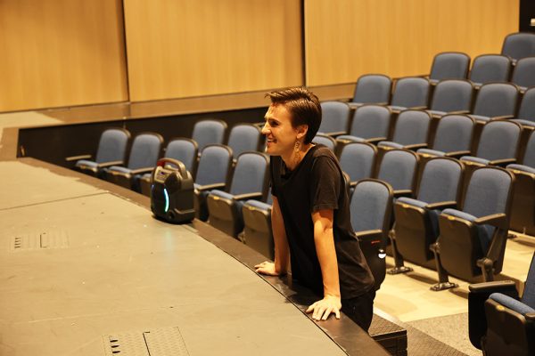 Theater Director Pearson Kunz leans on the auditorium stage, as they watch as their students belt a song from their upcoming show. The theater department's first show of the season Macbeth opens in November.