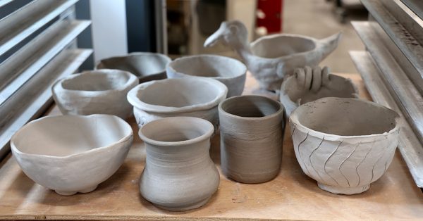 Greenware pots and bowls sit on a shelf. After these dry out for a few days, they will be loaded into a kiln to be fired into bisqueware. Then they are glazed and put into a glazeware firing, which is usually the last step in the creation of ceramics. 