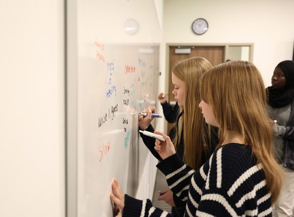 Students gather at the whiteboard to write down a few words that they feel describe older generations to help unpack perceptions. When back in their seats, they discuss whether these descriptions can lead to different geriatric care.