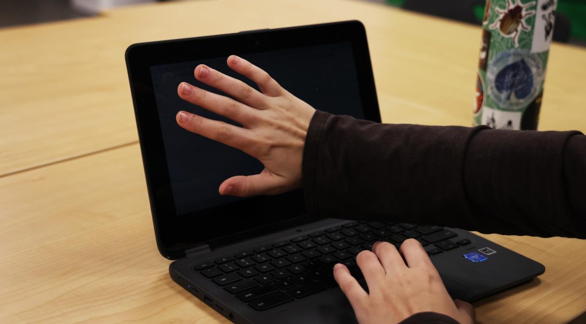 Senior Mailli Fisher covers her Chromebook with her hands. Fisher was
working on page layouts for this year’s yearbook.