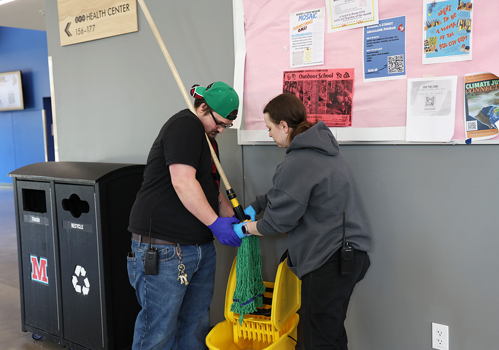 Custodians Cody Baez and Mckenna McVicker work together to help fix a mop. During lunch they observe in order to get messes quicker and more efficient. 