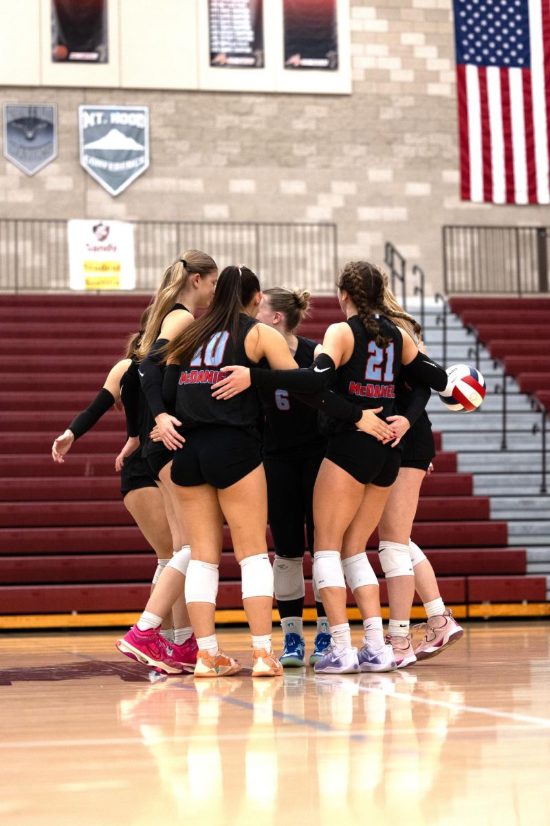 The team huddles together following their recent kill. The team celebrates as they regroup in the huddle. The huddles in between points helps the team connect before the next point. 