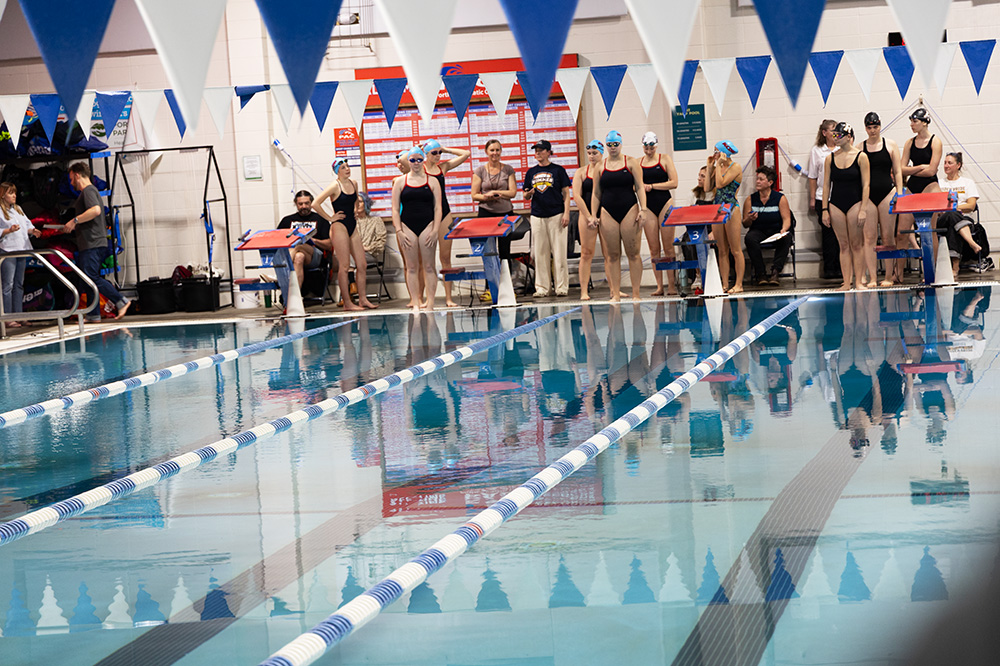 Members of the swim team prepare to mount the block. There is a mix of varsity and JV swimmers. This was at the beginning of the events.