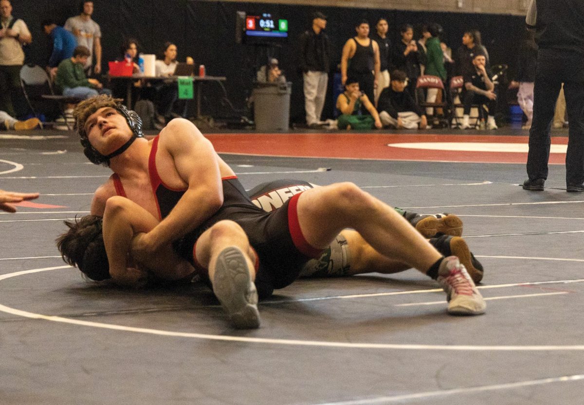 Senior boys Captain Lucas McCall-Petke looks up as he pins his opponent. McCall-Petke would go on to win the match against ____ at the Paul Larson Tournament..