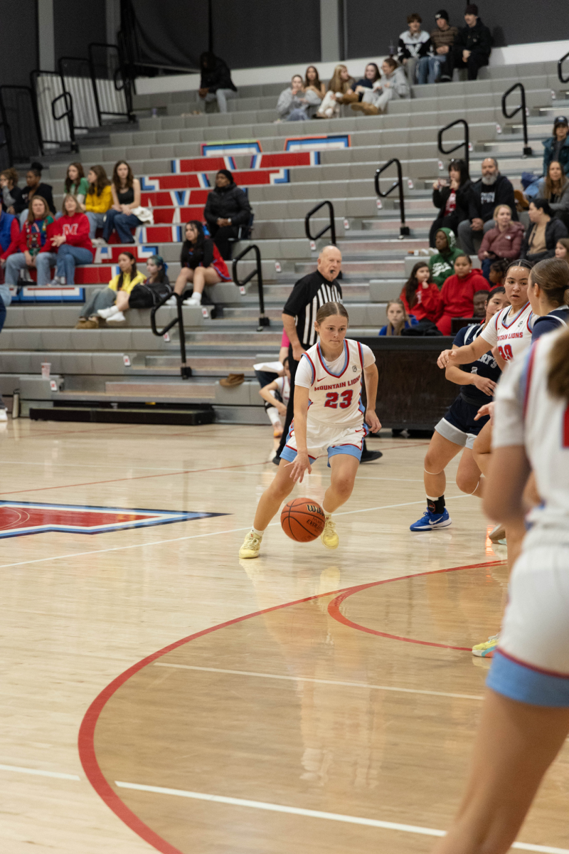 Junior Maeby Alderman is driving up the court, aiming for a bucket. Her teammates clear the lane.