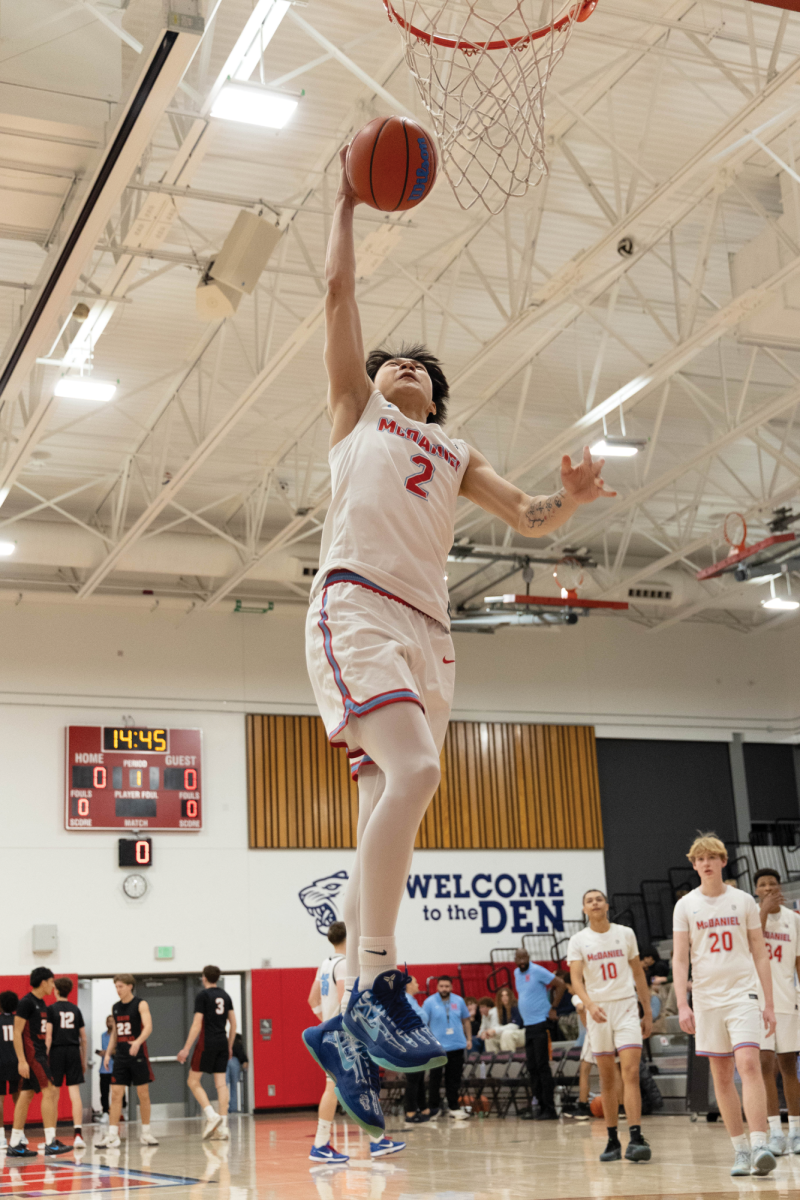 Senior captain Weiming Zhu goes for a dunk during layup lines, showing off his bounce before the game. The game took place Dec. 9 against David Douglas.