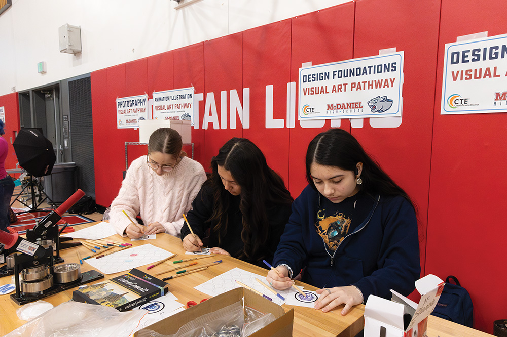 Freshmen Ida Bolanos, Camilla Teske and Addy Maddox draw designs that students can turn into stamps. Making stamps is apart of the visual art pathway.