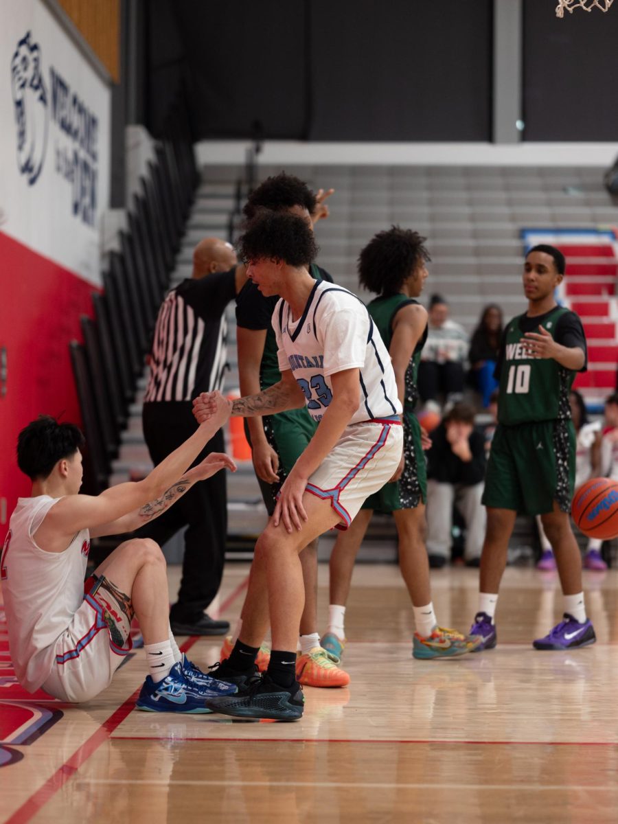Senior Antoine Robinson helps Zhu up during a stoppage after a big drive to the hoop. The duo scored the majority of the three pointers in the game.