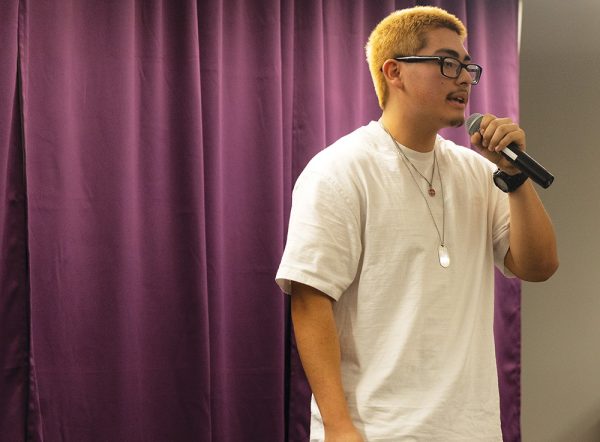 Senior Tony Salinas-Simon tells his story while his friends cheer him on. Salinas-Simon was the only senior in the school-wide slam.