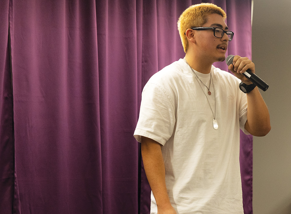 Senior Tony Salinas-Simon tells his story while his friends cheer him on. Salinas-Simon was the only senior in the school-wide slam.