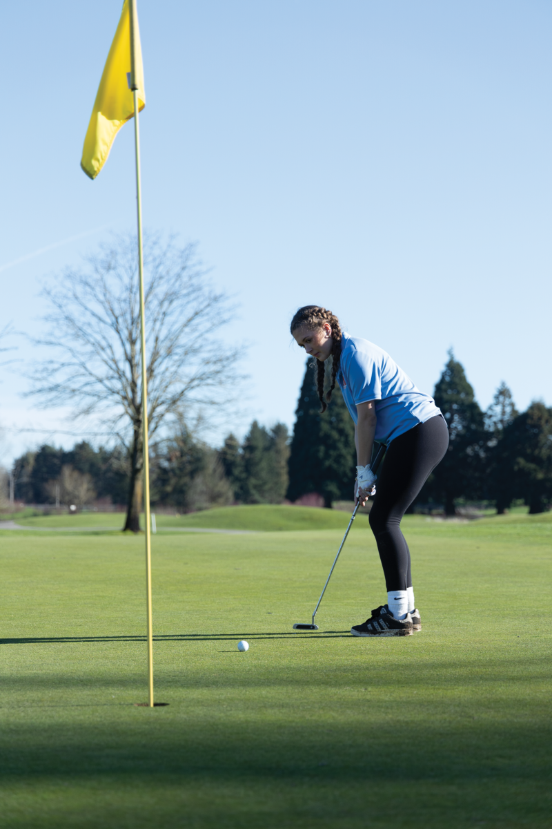 Sophomore Ohio Petersen putts the ball. Petersen focuses on her swing, having just the right amount of power, so the ball makes it in the hole.
