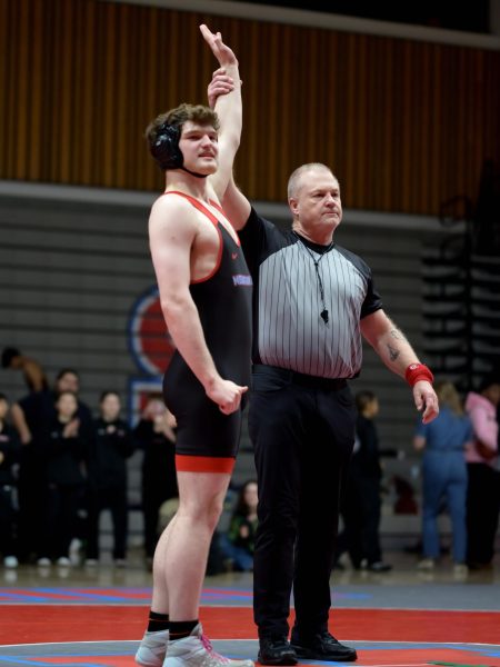 Two-time district champion Lucas McCall-Petke revels in the glory of his win during the Senior Night meet in February. McCall-Petke won automatically due to lacking an opponent in his weight class.