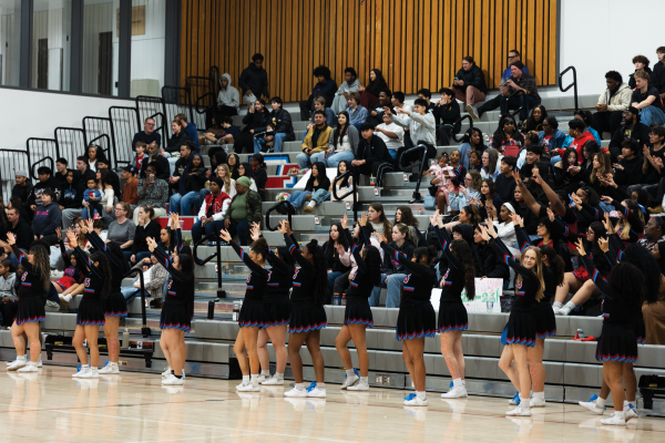 Building anticipation, the cheer team waits as McDaniel takes a free throw. All eyes are on the shooter.